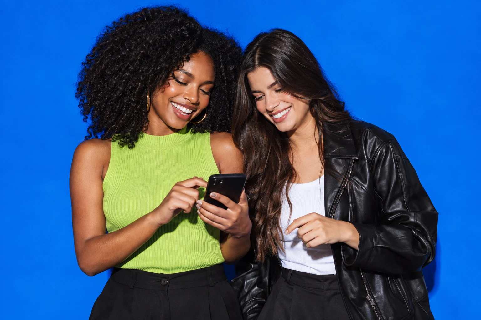 Duas modelos adultas compartilhando ideias em um estúdio criativo azul